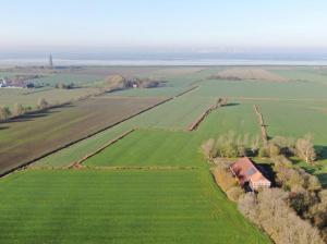 una vista aérea de una granja con un granero en un campo en Grashaus Leevke, en Krummhörn
