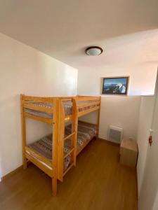 a room with two bunk beds in a room at La Foux 2 pièces in Allos