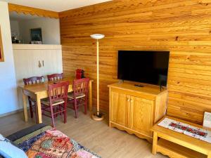 a living room with a dining table and a television at La Foux 2 pièces in Allos