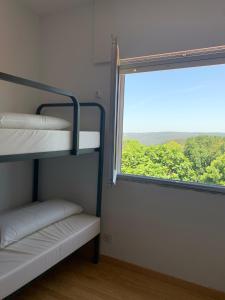 Pokój z łóżkiem piętrowym i oknem w obiekcie Albergue Alto da Pena EXCLUSIVE FOR PILGRIMS w mieście Negreira