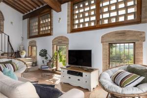 uma sala de estar com 2 sofás e uma televisão de ecrã plano em IL PODERINO - LUSSUOSO CASOLARE DI DESIGN em San Gimignano