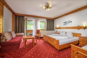グロースアルルにあるホテル フべルトゥスホフのベッドとソファ付きのホテルルーム