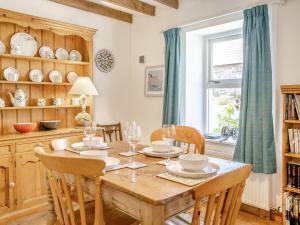 a dining room with a table and chairs and a window at Sea Pickle Cottage in Haverfordwest