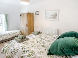 a bedroom with a bed and two green pillows at Sea Pickle Cottage in Haverfordwest