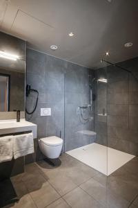 een badkamer met een douche, een toilet en een wastafel bij RiKu HOTEL Göppingen in Göppingen