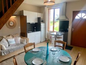 a living room with a table and a couch at Camping Les Pommiers in Sotteville-sur-Mer +27 photos