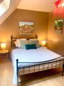 a bedroom with a large bed with two lamps at Camping Les Pommiers in Sotteville-sur-Mer