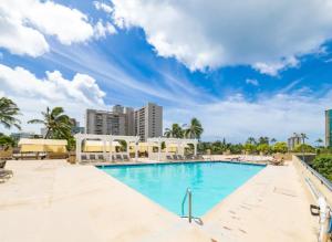 een zwembad in het resort met gebouwen op de achtergrond bij Vacation Apartments in Honolulu Hawaii in Honolulu