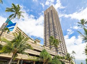 een hoog gebouw met palmbomen ervoor bij Vacation Apartments in Honolulu Hawaii in Honolulu
