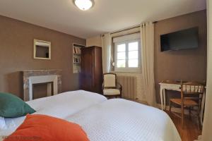 a bedroom with a bed and a fireplace and a television at Villa Matignon in Bagnoles de l'Orne