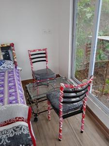 Pokój z 2 krzesłami, stołem i oknem w obiekcie Jandyal Farm House w mieście Malshej Ghat