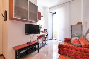 een woonkamer met een rode bank en een flatscreen-tv bij PrimoPiano - Tertulliano in Milaan