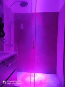 a bathroom with a shower with pink lighting at Top Apartment Roma 2 in Rome