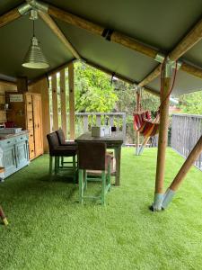 a patio with a table and chairs and a playground at Rendes Glamping in Balatonrendes