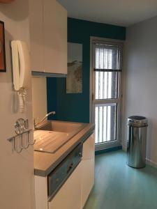 a kitchen with a sink and a window at A 50m de la mer in Agon Coutainville