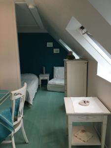 a attic room with a bed and a table and a chair at A 50m de la mer in Agon Coutainville