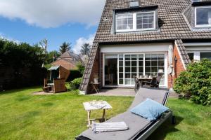 a backyard with a couch and a table in the grass at Meeresgarten in Tinnum