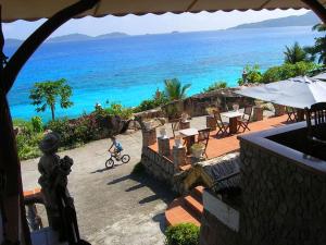 una persona montando una bicicleta junto al océano en Hotel L'Ocean, en La Digue