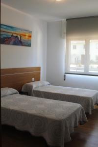Habitación con 2 camas y ventana en Albergue Alto da Pena EXCLUSIVE FOR PILGRIMS, en Negreira