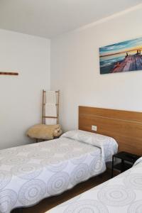 1 dormitorio con 2 camas y 1 silla en Albergue Alto da Pena EXCLUSIVE FOR PILGRIMS, en Negreira
