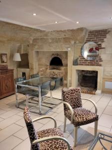 a room with a table and chairs and a fireplace at Le Gite de la Loire in Rochecorbon
