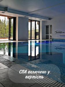a swimming pool with blue water in a building at Girski Hotel&Spa in Bukovel