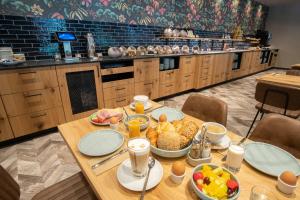 a table with breakfast food on it in a kitchen at RiKu HOTEL Göppingen in Göppingen