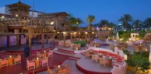 an outdoor patio with tables and chairs at night at Private Luxury Villas at Sharm Dreams Resort in Sharm El Sheikh