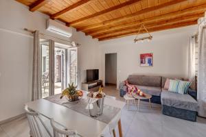 a living room with a table and a couch at TAKIS GUESTHOUSE-Orneda-HERMOUPOLIS in Ermoupoli