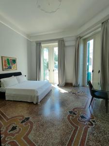 a bedroom with a bed and a desk and windows at B&B Del Duomo in Messina