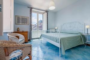 sypialnia z łóżkiem i krzesłami oraz oknem w obiekcie Gli Iris Apartments by Wonderful Italy w mieście Linguaglossa
