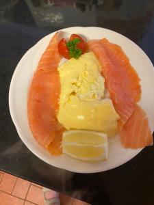 un plato de comida con salmón, queso y tomates en Oakfield en Kenmare