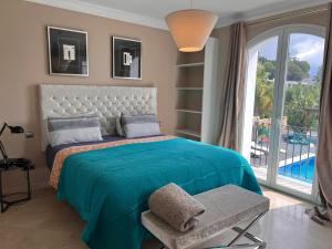 マルベーリャにあるVilla Maracanaのベッドルーム1室(ベッド1台、大きな窓付)