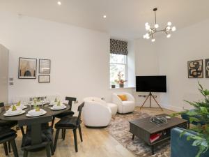 a living room with a table and a tv at The Theobold Suite Stone Cross Mansion in Ulverston