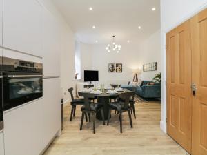 a dining room and living room with a table and chairs at The Theobold Suite Stone Cross Mansion in Ulverston