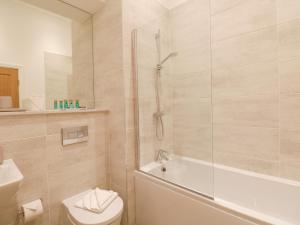 a bathroom with a shower and a toilet and a sink at The Theobold Suite Stone Cross Mansion in Ulverston +49 photos