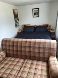 a bed and a couch in a bedroom at Wee Shot in Tain