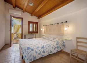 een slaapkamer met een bed en een stoel bij Edomat in Monserrato