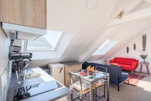Il comprend une cuisine et un salon avec un canapé rouge. dans l'établissement TERANGA - Studio proche CHU avec grande terrasse, à Rennes