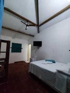 a bedroom with a bed and a ceiling fan at Pousada e Restaurante Tremembé in Icapuí