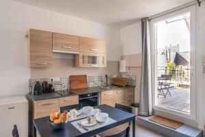 cocina con mesa y ventana grande en YOKOSO - Studio proche CHU avec terrasse, en Rennes