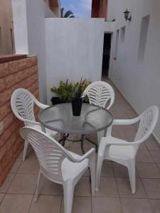 a white table and chairs with a potted plant at Apartamento Kalma 1 in Corralejo