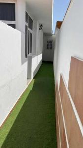 a hallway of a white building with green grass at Apartamento Kalma 1 in Corralejo