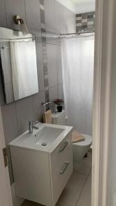 a white bathroom with a sink and a toilet at Apartamento Kalma 1 in Corralejo