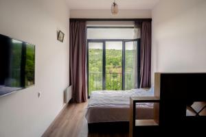 a bedroom with a bed and a large window at RIS Holiday Apartments Tsaghkadzor in Tsaghkadzor