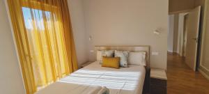 a small bedroom with a bed with a yellow curtain at MIRADOR DEL TRANSITO in Toledo