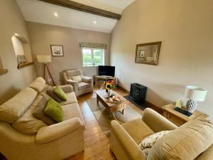 a living room with two couches and a tv at Fieldsview in Wrexham