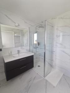 a white bathroom with a sink and a shower at Apartamentos Seijo in Villalba