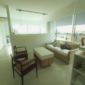 een woonkamer met een bank en een tafel en stoelen bij Ombu Loft Olivos, Vista al Rio in Olivos