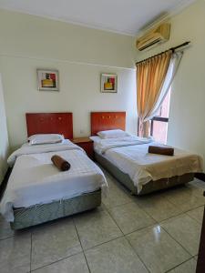 a bedroom with two beds and a window at Marina Court Kota Kinabalu in Kota Kinabalu